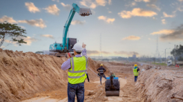 Surveyor engineer wearing safety uniform and helmet with equipme