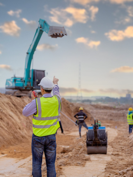 Surveyor engineer wearing safety uniform and helmet with equipme