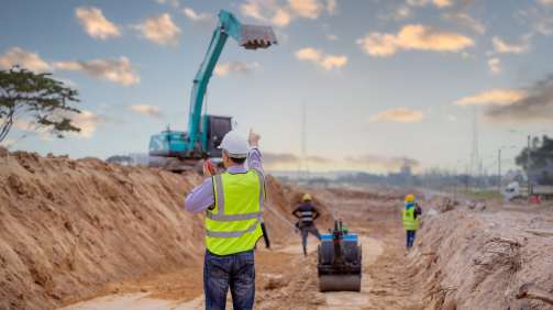 Surveyor engineer wearing safety uniform and helmet with equipme